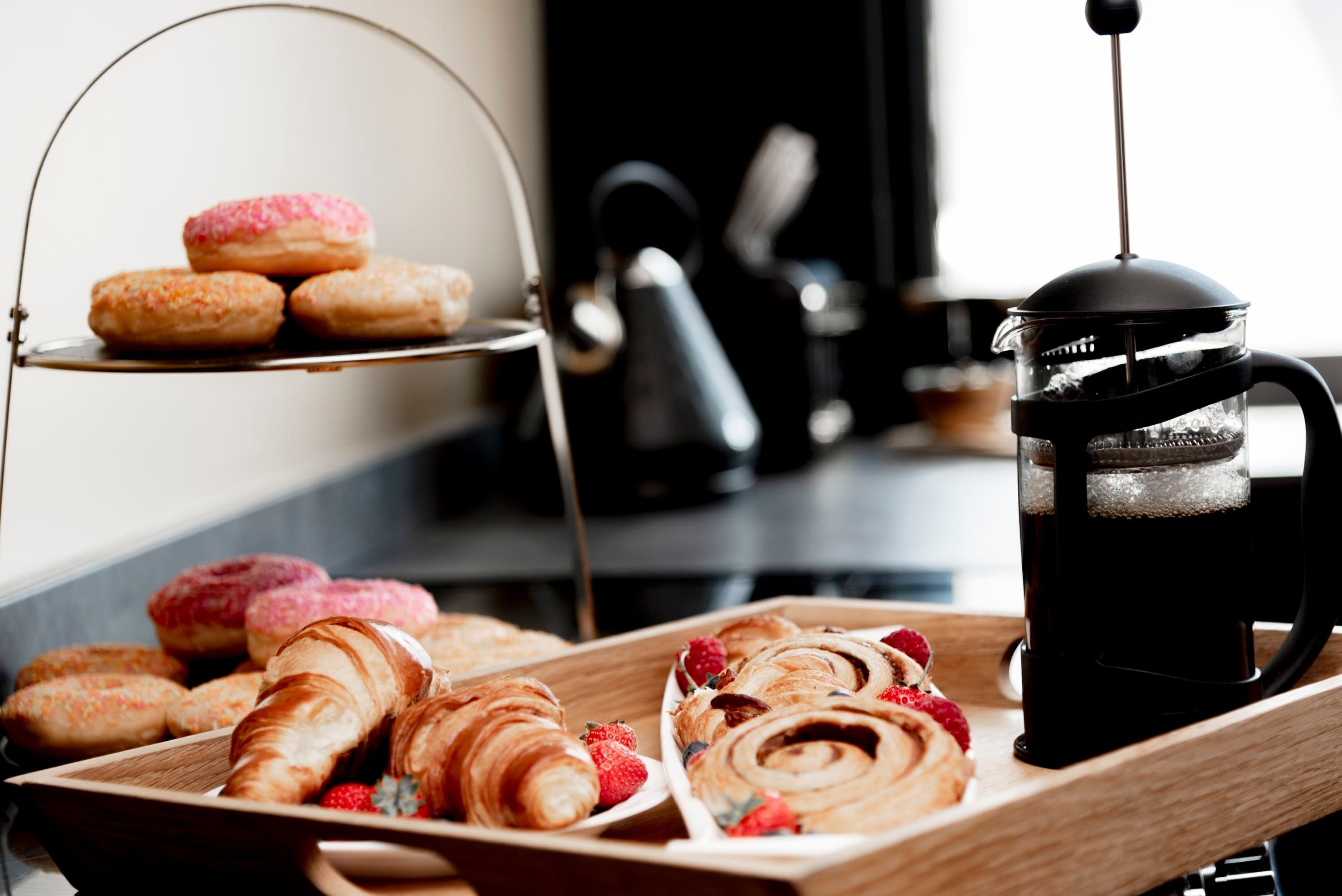 A tray of pastries and a coffee maker.