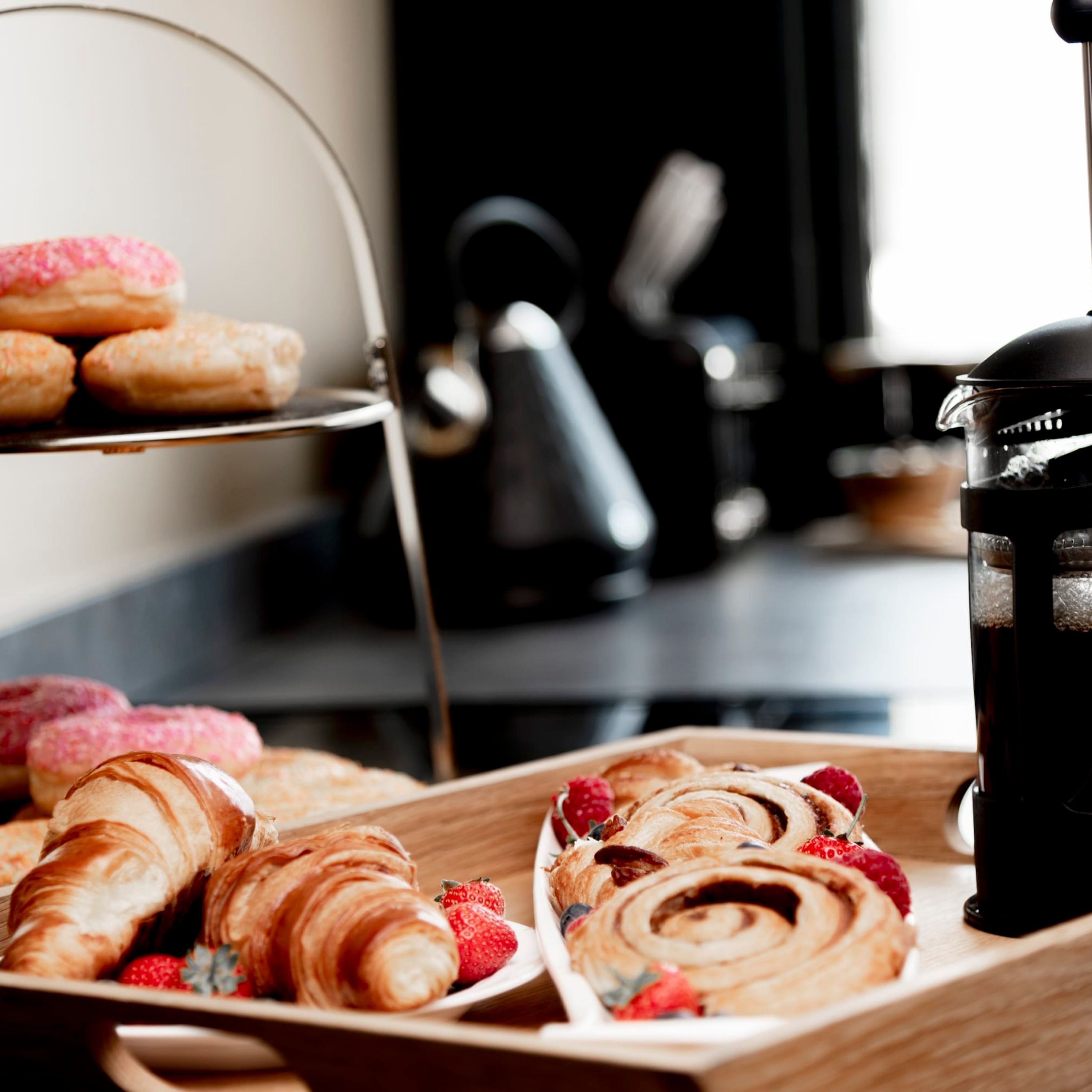 A tray of pastries and a coffee machine.