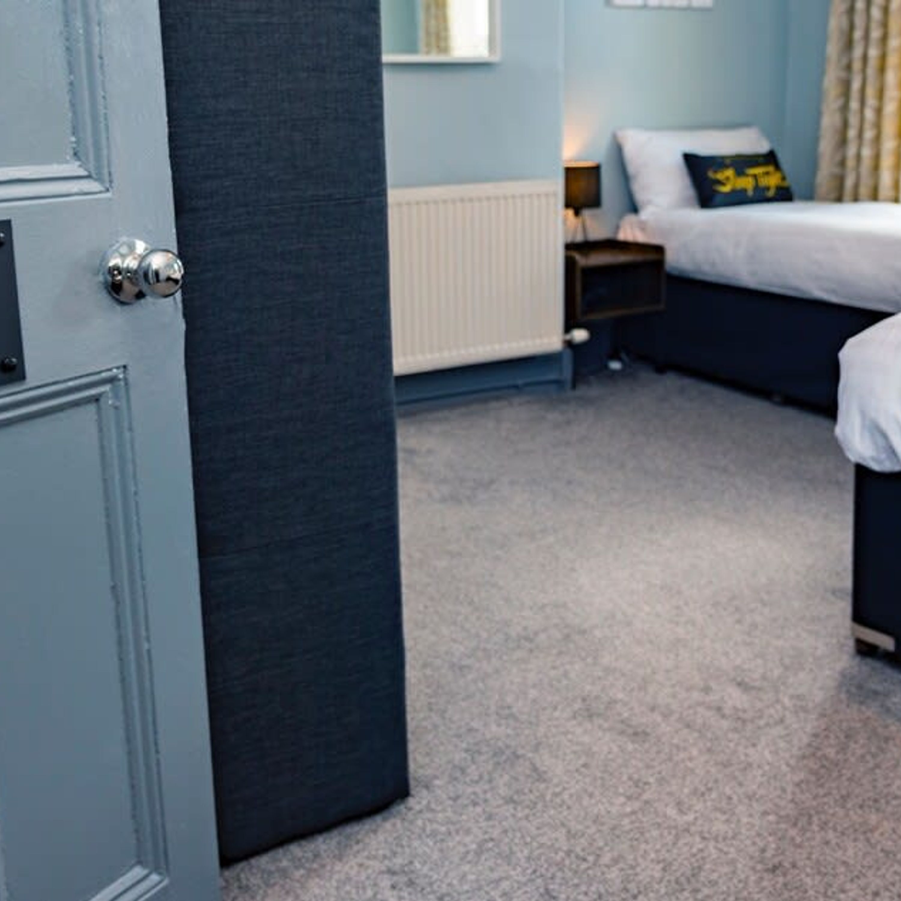 A bedroom with a bed, a nightstand, and a radiator.