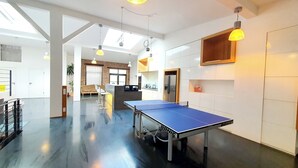 A spacious room with a ping pong table, a kitchen area, and a seating area with a sofa and chairs. - Loft für Besondere Momente (Mannheim)
