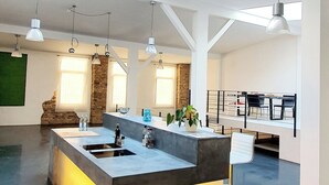 A spacious, modern kitchen with a central island, pendant lighting, and a skylight. - Loft für Besondere Momente (Mannheim)