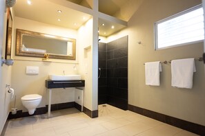 Enjoy a contemporary bathroom experience with a sleek shower, toilet, and ample lighting.