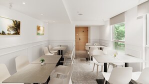 Een moderne eetruimte met witte tafels en stoelen, een houten deur en kunstwerken aan de muur.