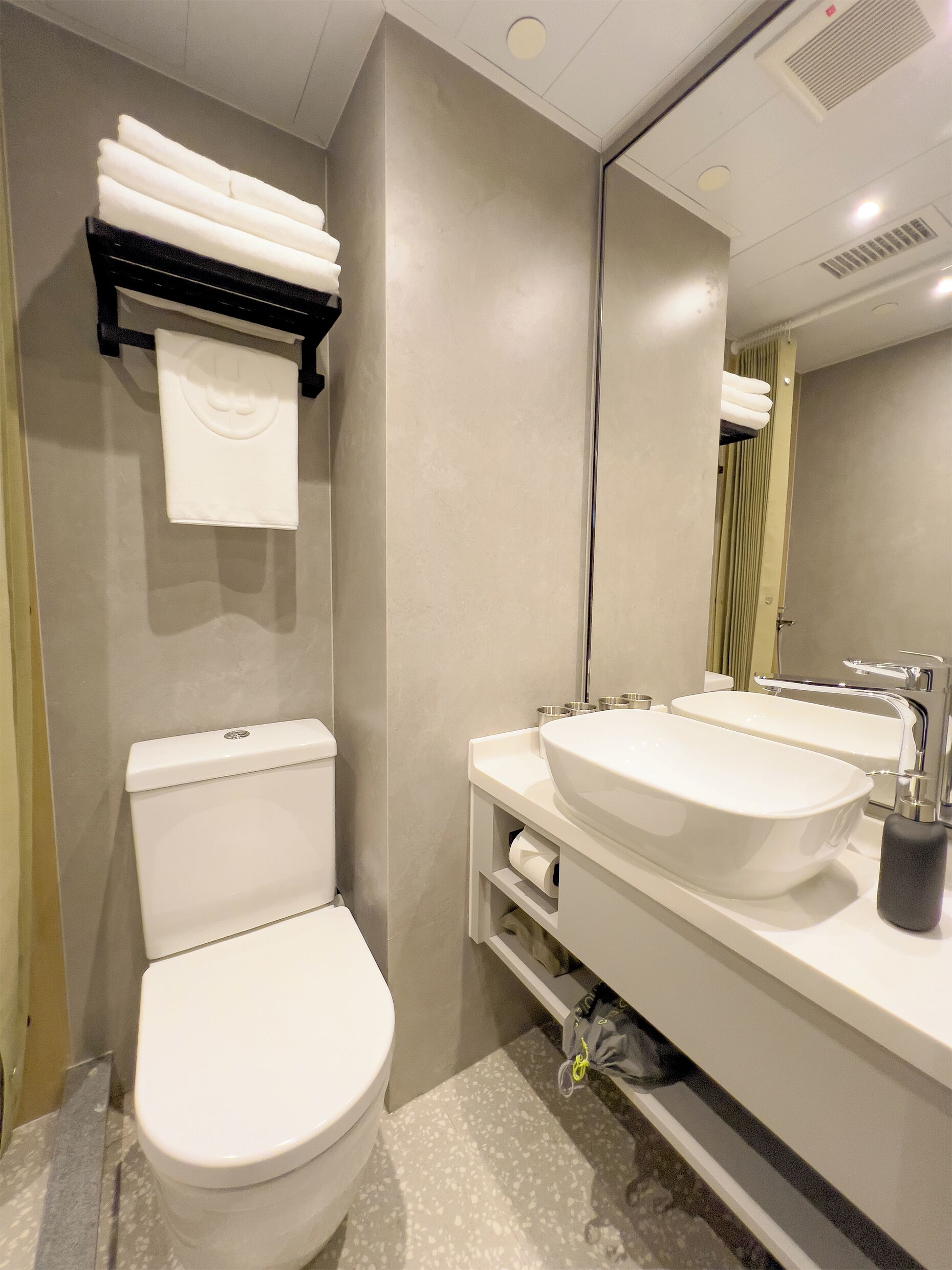 Un baño moderno con inodoro, lavabo y espejo.