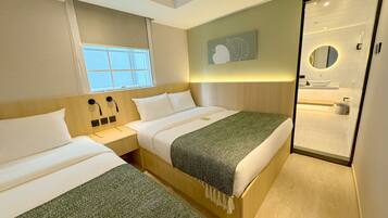 Une chambre d’hôtel avec deux lits, une grande fenêtre, une œuvre d’art accrochée au mur et une salle de bain visible à travers une porte en verre.