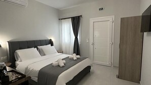 Une chambre à coucher moderne avec un lit, une table de chevet et une armoire.