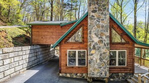 A cabin with a stone chimney, wooden walls, and a green roof. - Cataloochee Chalet Mountain Views/Hot Tub/Fire Pit (Maggie Valley)