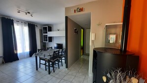 Ein modernes Wohnzimmer mit Essbereich, einem schwarzen Schrank mit Verzierungen und einem 'WELCOME'-Schild an der Wand.