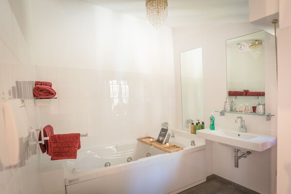 A modern bathroom with a freestanding bathtub, a vanity with a mirror and shelves, and a chandelier. - Majestic Villa in Hills of Florence with Gardens Gym Jacuzzi and Sauna (Fiesole)