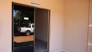 A reception area with a sliding door, a welcome mat, and a sign above the door. - Amariah Guesthouse Newstance (Kasane)