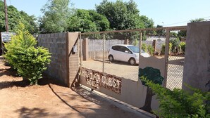 A gated area with a sign reading "MARIATH GUEST HOUSE". - Amariah Guesthouse Newstance (Kasane)