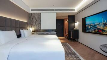 Habitación de hotel moderna con una cama grande, televisor de pantalla plana, vistas a la ciudad y una pequeña zona de escritorio.