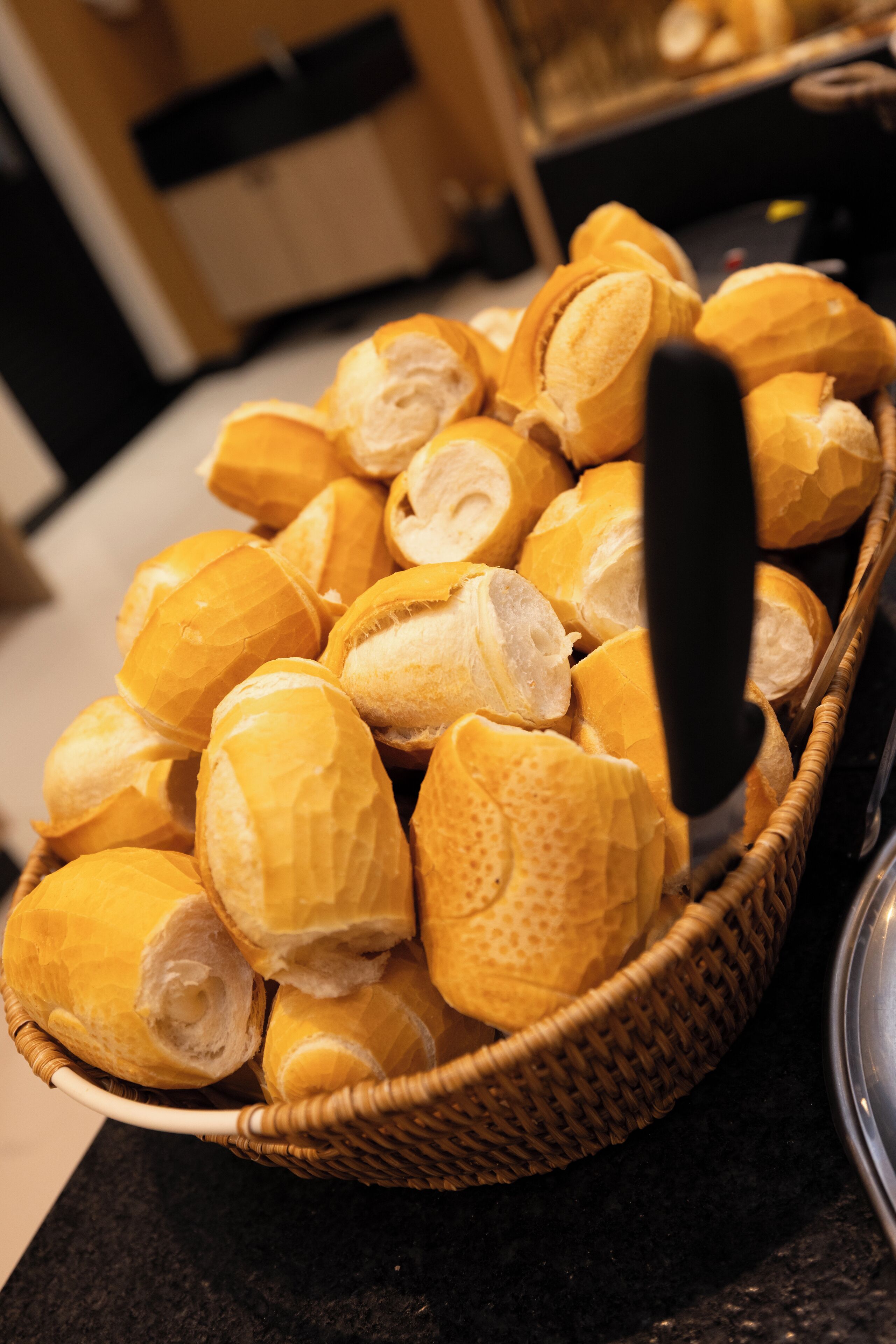 A basket filled with bread rolls on a kitchen counter.