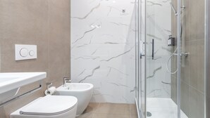 A modern bathroom with a glass-enclosed shower, a toilet, and a bidet. - Rhome Vatican Rooms (Rome)