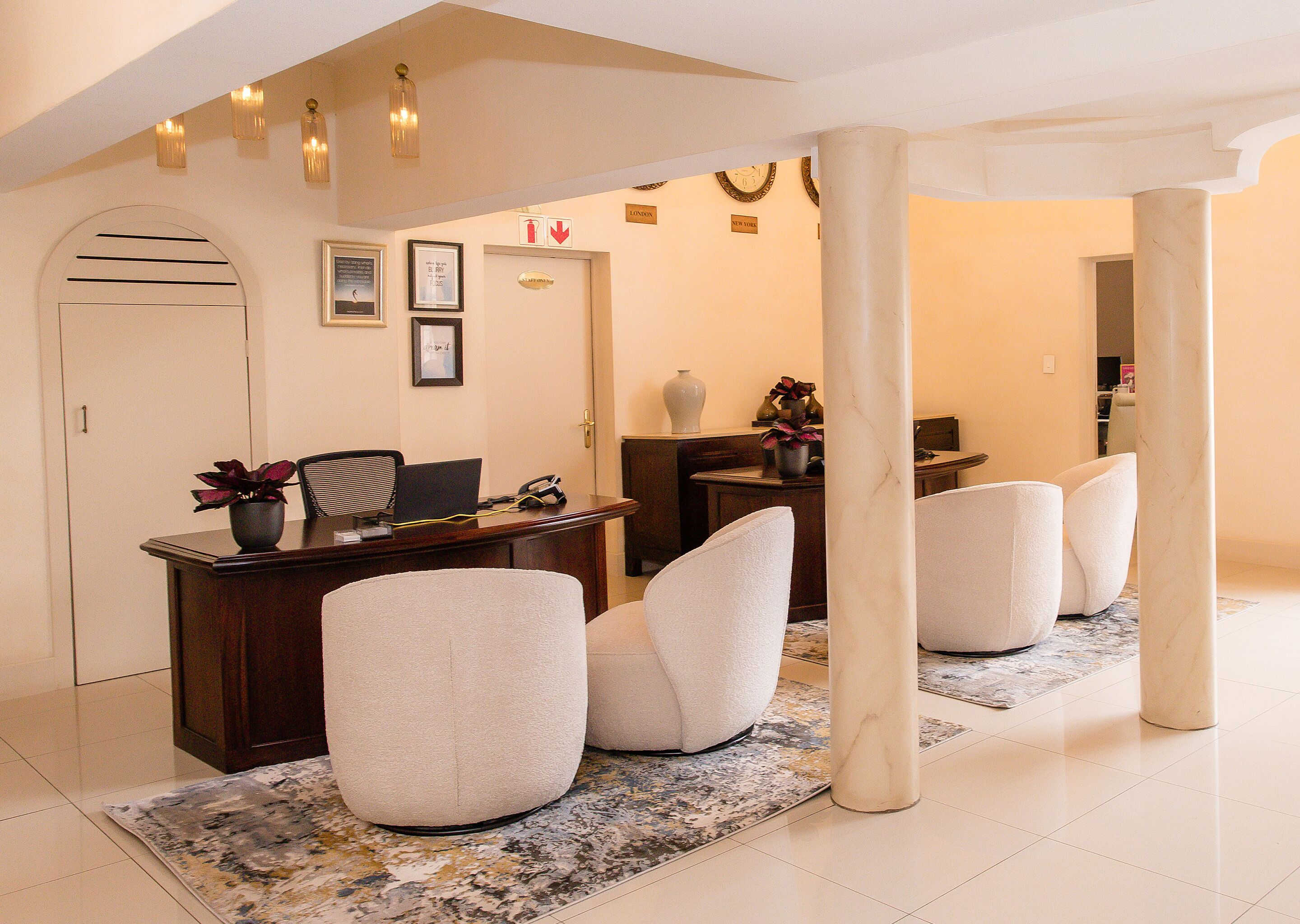 Un moderno vestíbulo de hotel con una recepción, zona de estar y una columna grande.