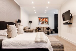 A modern hotel room with a large bed, a sofa, a TV, and a painting on the wall. - 10 2nd Avenue Boutique Hotel by Dream Resorts (Johannesburg)