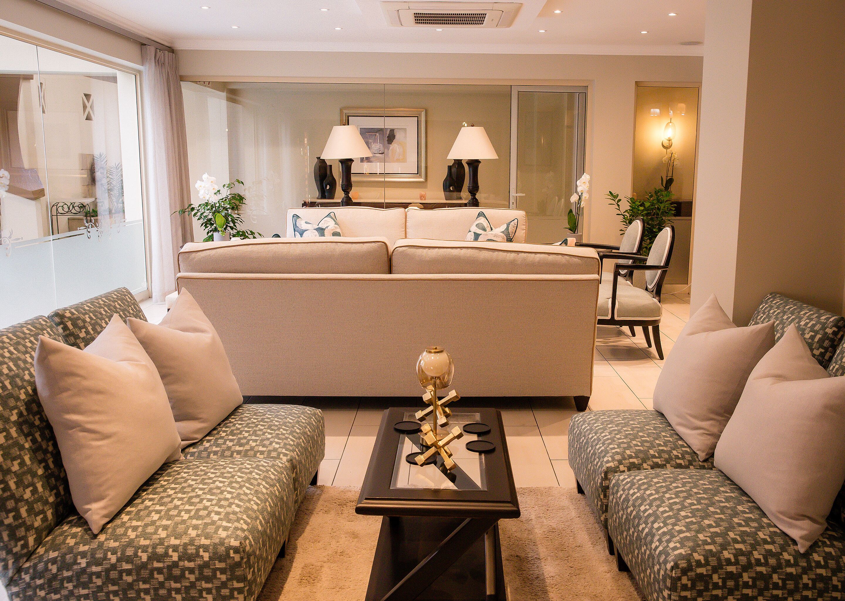 A modern living room with a sofa set, a coffee table, and a dining area with chairs.