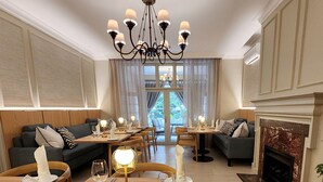 Comedor con candelabro, muebles de madera y chimenea.