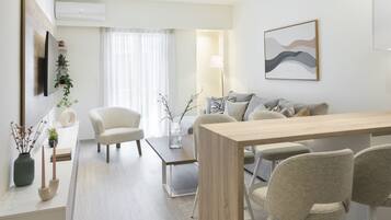 Appartamento Deluxe, vista città | Area soggiorno | TV 50 pollici con canali via cavo