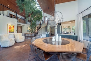 A spacious dining area with a large wooden table, surrounded by chairs, and a staircase leading to an upper level. - Singletree-Paragon by Curate Telluride-Pickleball, Pool Tbl, Hot Tub, Ping Pong (Mountain Village)