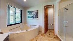 Un bagno con vasca, finestra, porta e zona doccia.