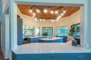 Una cucina moderna con isola centrale, elettrodomestici integrati e ampie finestre.