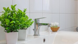 A bathroom with a white sink, chrome faucet, and a potted plant. - La Ringhiera Fiorita 201 Autodromof1 Villa Reale (Monza)