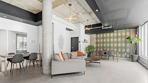 A spacious, modern interior with a large dining area, a sofa set, and a coffee table. - Le Downtown (rooftop pool and gym) (Québec)