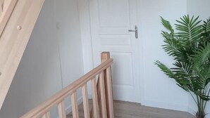 A wooden staircase with a white door at the top. - - L'olivier - (Dozulé)