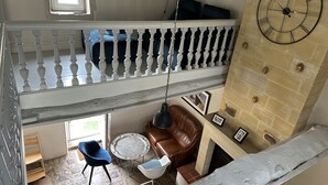 Un soggiorno su più livelli con una scala, una sveglia e un camino.