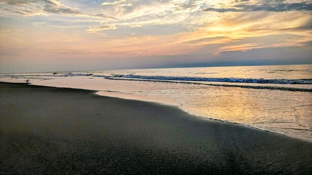 Una playa con olas y cielo despejado.