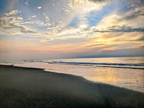 Ein Strand mit Wellen und blauem Himmel.