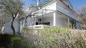 A white building with a flat roof, a chimney, and a satellite dish.