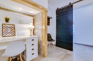 Un espacio de oficina moderno con un escritorio, una silla y un gran ventanal corredera.