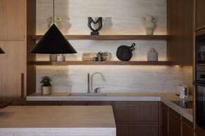 A modern kitchen with a central island, a sink, and a built-in oven.