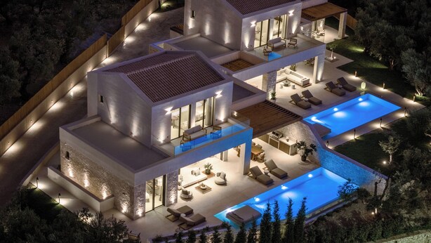 A modern multi-story house with a swimming pool, outdoor seating, and a well-lit exterior. - Valerozo Immensa Villa (Ionian Islands, Zakynthos)