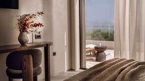 A modern room with a view of the sea, a desk with a vase of dried flowers, and a cozy bed area. - Valerozo Immensa Villa (Ionian Islands, Zakynthos)