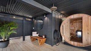 Un espace spa moderne comprenant un sauna en bois, un coin salon avec un banc et une petite table, un grand miroir et une plante en pot.