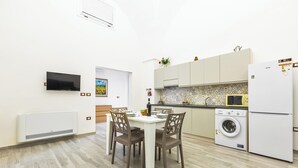 A modern kitchen with a dining area, white appliances, and a tiled backsplash. - 3833 Residenza Nonna Lucia - Mono by Barbarhouse (Ugento)