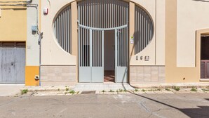 A building with a large arched entrance, a gated driveway, and a small porch area. - 3833 Residenza Nonna Lucia - Mono by Barbarhouse (Ugento)