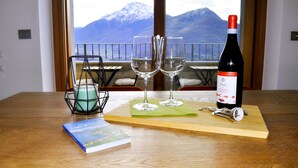 Una mesa con dos copas de vino, una vela, un libro y una botella de vino.