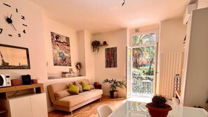 A compact living space with a sofa, a dining table, and a kitchen area. - New apartment in the city center cozy and quiet near the station (La Spezia)