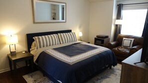 A neatly arranged bedroom with a bed, bedside tables, a lamp, a leather armchair, and a mirror on the wall. - Spacious 3 Bd 3.5 Bath Auburn Townhome only 1 Mile from Campus - Pet Friendly (Auburn)