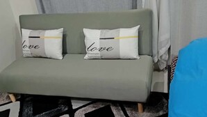 Ein Sofa mit zwei Kissen, eines mit dem Wort 'love' und das andere mit 'welcome to pairs'.