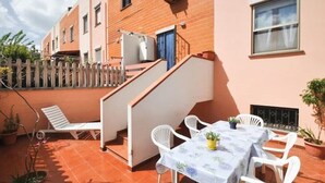 Eine Terrasse mit Tisch, Stühlen und einem Blumentopf.