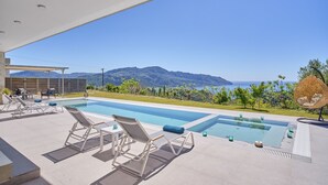 Une piscine avec des chaises longues et une vue sur les montagnes.