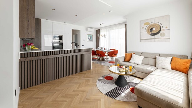 A modern living room with a sofa, coffee table, and dining area. - Rausion Luxury Apartments (Dubrovnik)