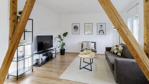Un salon moderne avec un téléviseur, un canapé et une table basse.
