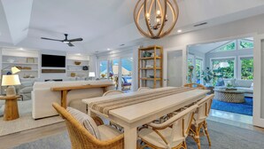 A spacious living area with a dining table, wicker chairs, a ceiling fan, and a large window. - 4 Cannon Row at The Sea Pines Resort (Hilton Head Island)