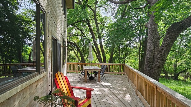 A wooden deck with outdoor furniture, a table, and chairs.